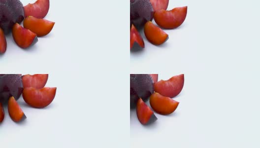 季度框架。用微距拍摄大紫梅花梅的一整个和几小部分，带有水滴。慢慢旋转在转盘上孤立的白色背景。特写镜头。高清在线视频素材下载