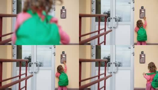 小女孩来到门口，使用入口对讲机高清在线视频素材下载