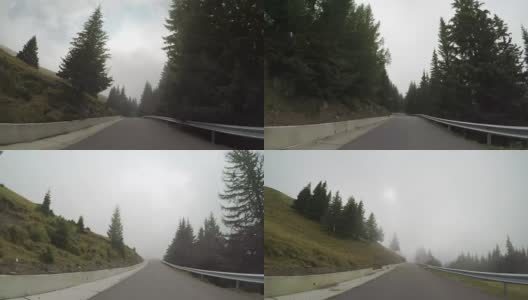 在一个阴沉沉的日子里，从汽车上看到的山林路高清在线视频素材下载
