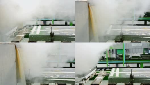 在橡胶枕厂的传送带上，用热蒸汽将金属乳胶枕模具从机器上移出高清在线视频素材下载