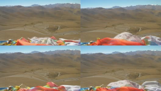 近距离观看彩色的经幡飘扬在瓜拉山口蜿蜒的道路上高清在线视频素材下载