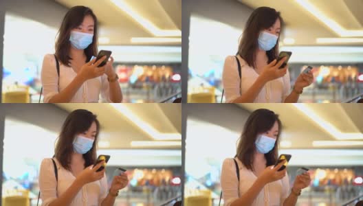 年轻的亚洲妇女戴着防护口罩和网上购物高清在线视频素材下载
