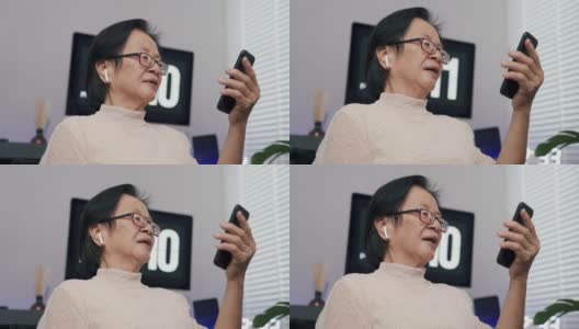 奶奶在家里用智能手机和孙子聊天。高清在线视频素材下载