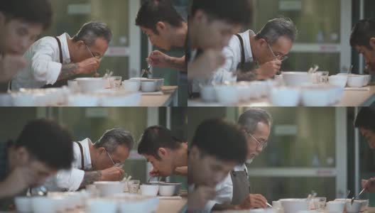 专业的亚洲华人高级男子咖啡师鉴赏家表演咖啡杯品尝咖啡杯用勺子高清在线视频素材下载