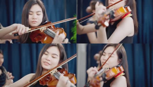 在节日聚会上演奏小提琴的年轻亚洲女人高清在线视频素材下载