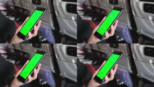 近距离女人的手看在绿色屏幕的手机应用程序在飞机座位高清在线视频素材下载