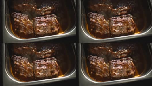 在餐厅厨房旋转的热腾腾的肉排配肉汁煮汁高清在线视频素材下载