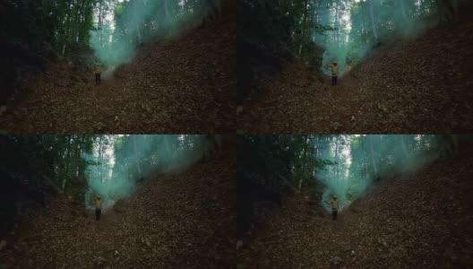 人在森林中持有绿色烟雾- 4K分辨率高清在线视频素材下载