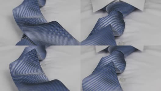 一个蓝色领带躺在白色衬衫上的特写。多莉。高清在线视频素材下载