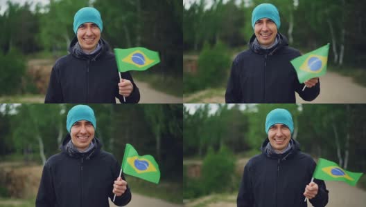 慢动作肖像快乐的家伙旅行者挥舞巴西国旗和看着相机与高兴的微笑。幸福，环游世界，游历各国理念。高清在线视频素材下载