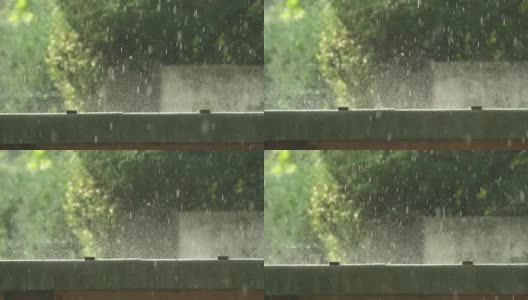 微景慢镜头:雨滴落在地上，溅起水花，在清晨的阳光下闪闪发光高清在线视频素材下载