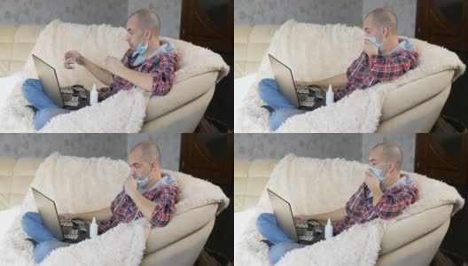 一名男子戴着防护面具坐在沙发上，通过视频链接向医生咨询如何治疗这种疾病。高清在线视频素材下载