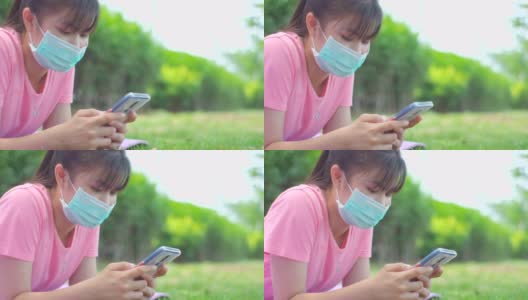 新常态，少女在新冠肺炎疫情下戴口罩使用手机高清在线视频素材下载