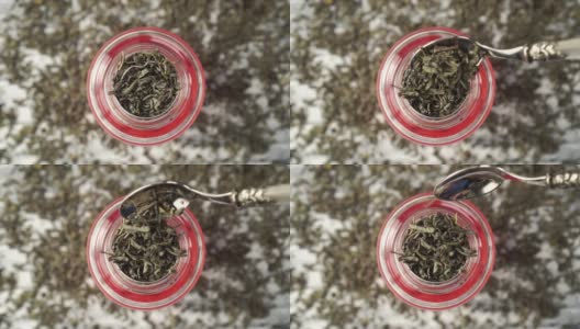 绿茶。干燥的卷叶落入玻璃茶壶特写高清在线视频素材下载