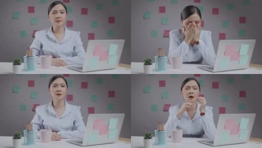 一名亚洲女性在使用笔记本电脑工作时发烧，打喷嚏，坐在家里的办公室里。高清在线视频素材下载