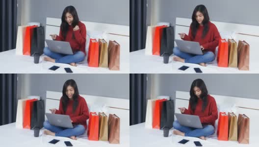开朗的女人在床上用笔记本电脑上网购物高清在线视频素材下载