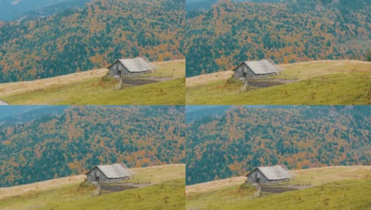 秋天风景如画的喀尔巴阡山脉为背景的牧羊人所建的旧木制废弃木屋。破败的废弃建筑高清在线视频素材下载