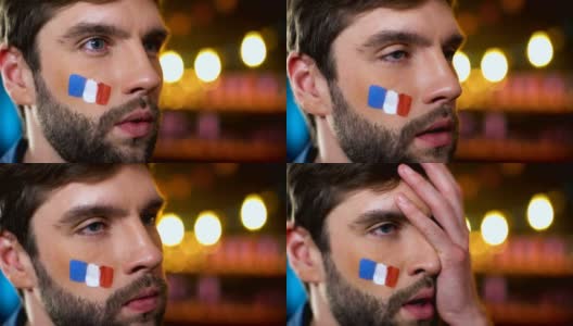 焦急的法国球迷与彩旗在脸颊使捂脸，失望高清在线视频素材下载