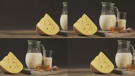 旧木桌上放着一块楔形瑞士奶酪和一壶牛奶高清在线视频素材下载