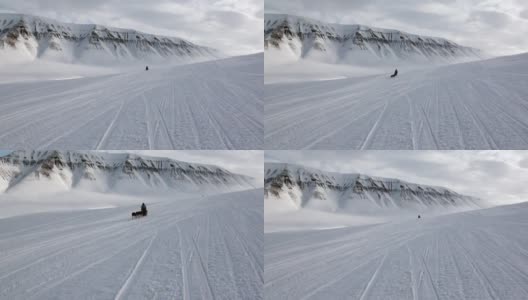 在北极圈北极，哈士奇爱斯基摩人骑着狗拉雪橇的白色雪道。高清在线视频素材下载