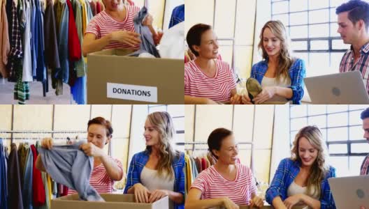 在志愿者整理捐赠箱里的衣服时，一个人在用手提电脑工作高清在线视频素材下载