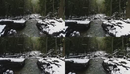 雪覆盖着冻结的巨石，沿着河床流动的水高清在线视频素材下载