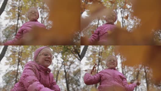 微笑的女孩在秋天扔枫叶高清在线视频素材下载