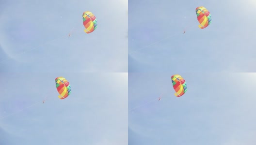 一艘船拖着五彩缤纷的降落伞在空中飞行高清在线视频素材下载