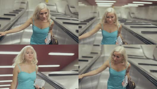 美丽的金发女郎在地铁的移动楼梯上升起高清在线视频素材下载