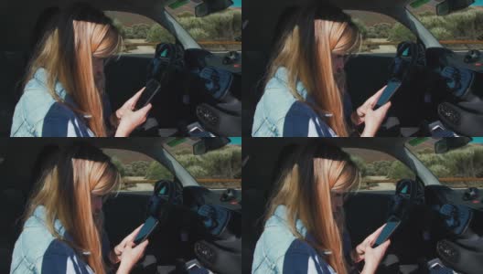 一位穿着牛仔夹克的金发美女坐在汽车副驾驶座上，用智能手机在社交网络上发送信息。阳光照亮了模特儿的头发高清在线视频素材下载