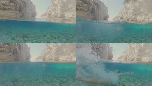 一名年轻女子潜入克罗地亚亚得里亚海的岩石浅海中高清在线视频素材下载