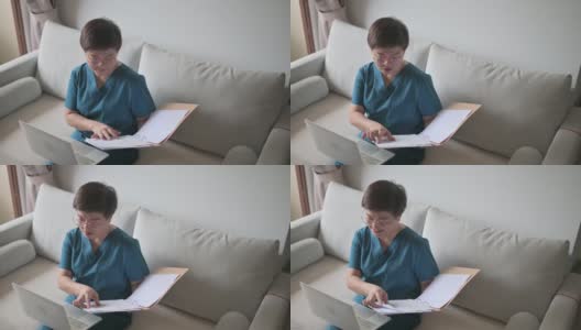 亚裔华裔女医生在家工作，在客厅用笔记本电脑咨询她的成年病人高清在线视频素材下载