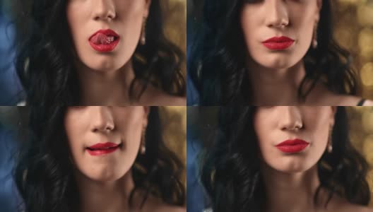 特写性感的黑发女人舔舌头，咬红色的嘴唇摆迪斯科散拍。4k Dragon RED摄像机高清在线视频素材下载