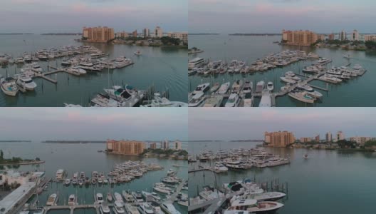 从空中俯瞰萨拉索塔市中心和金门角天际线上的豪华公寓，日落前的清晨，码头上挤满了游艇和船只。高清在线视频素材下载