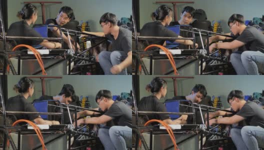 三个十几岁的亚洲学生团队合作开发在项目工程课上通过笔记本电脑控制在学校的一个研究实验室工作到深夜。有创意的设计师测试机器人。技术、团队合作的概念高清在线视频素材下载