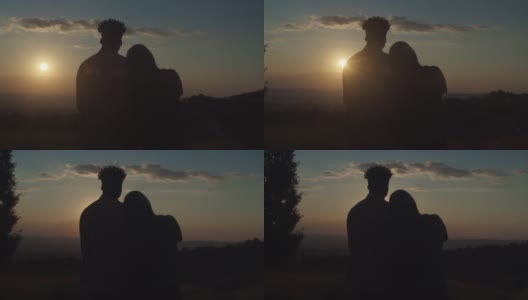 一对情侣的剪影，站在爱的拥抱，享受风景山自然日落高清在线视频素材下载