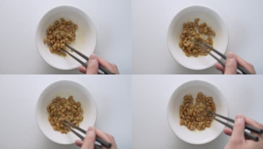 用慢镜头在白色碗里搅拌纳豆(发酵的日本大豆)高清在线视频素材下载