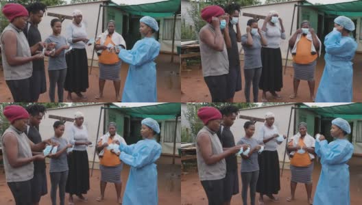 非洲黑人女护士向农村居民点的人们演示如何戴上防护口罩，以预防Covid-19高清在线视频素材下载