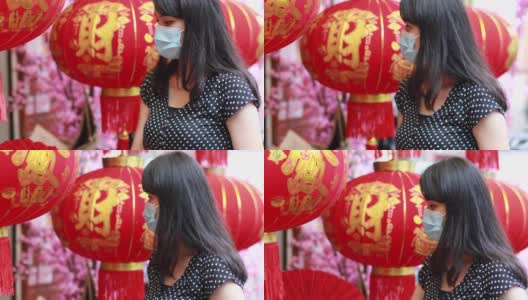 年轻美丽的亚洲女性，带着防护口罩，购买中国传统服饰和装饰高清在线视频素材下载