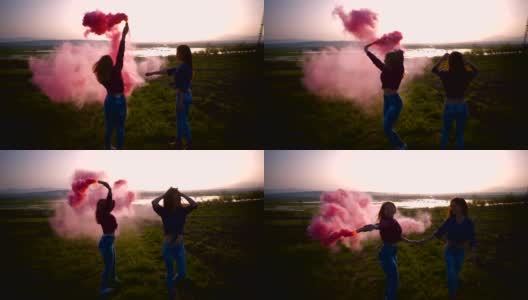 两名年轻女子拿着一枚粉色烟雾弹在空中转圈，慢镜头高清在线视频素材下载