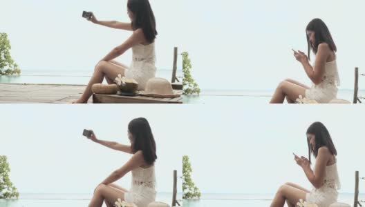 美丽年轻的亚洲女人喝椰子汁沿着海滩。高清在线视频素材下载