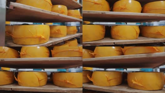 工厂仓库货架上的包装奶酪轮。奶酪生产高清在线视频素材下载