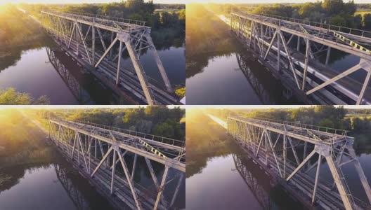 日落时分，一列高速列车驶过河上的一座桥高清在线视频素材下载