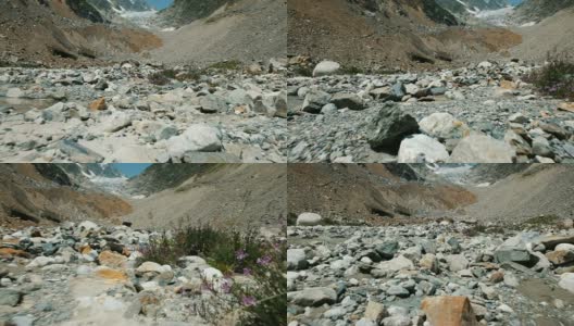 石质冰碛在山上以冰川为背景，运动缓慢。山涧和野花，镜头移动高清在线视频素材下载