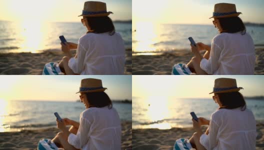在海滩上使用手机高清在线视频素材下载