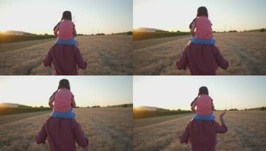 父亲背着他的女儿在日落时穿过麦田日落时穿过麦田高清在线视频素材下载