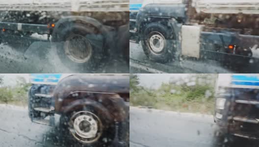 在大雨滂沱的公路上驶过的卡车。车轮在车窗水滴上的细节高清在线视频素材下载