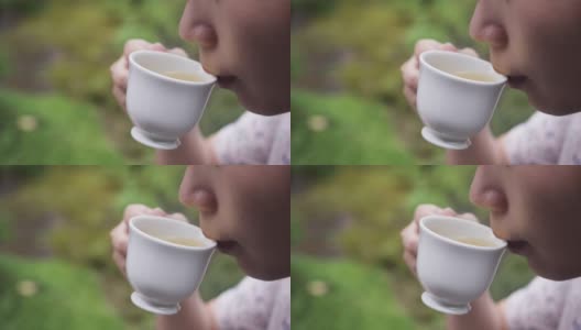 用拷贝空间拉近亚洲女孩在花园喝茶的距离高清在线视频素材下载