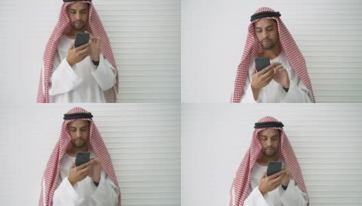 阿拉伯商人专业持有现代智能手机使用浏览互联网发现信息社交或下载与应用程序。在新常态下，在社交距离之间在线工作或检查企业利润。高清在线视频素材下载