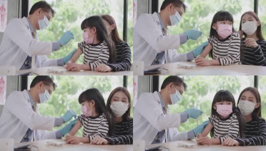 感受少女对针头的恐惧，亚洲资深男医生戴着卫生口罩在亚洲患者的手臂上注射疫苗，一个孩子带着姐姐一样的朋友过来，表景高清在线视频素材下载